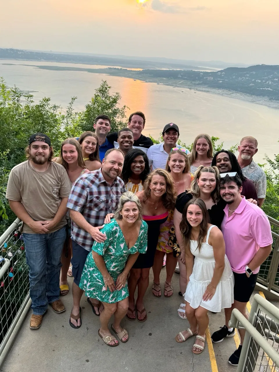 Rebelz staff and family posing on a balcony overlooking the water